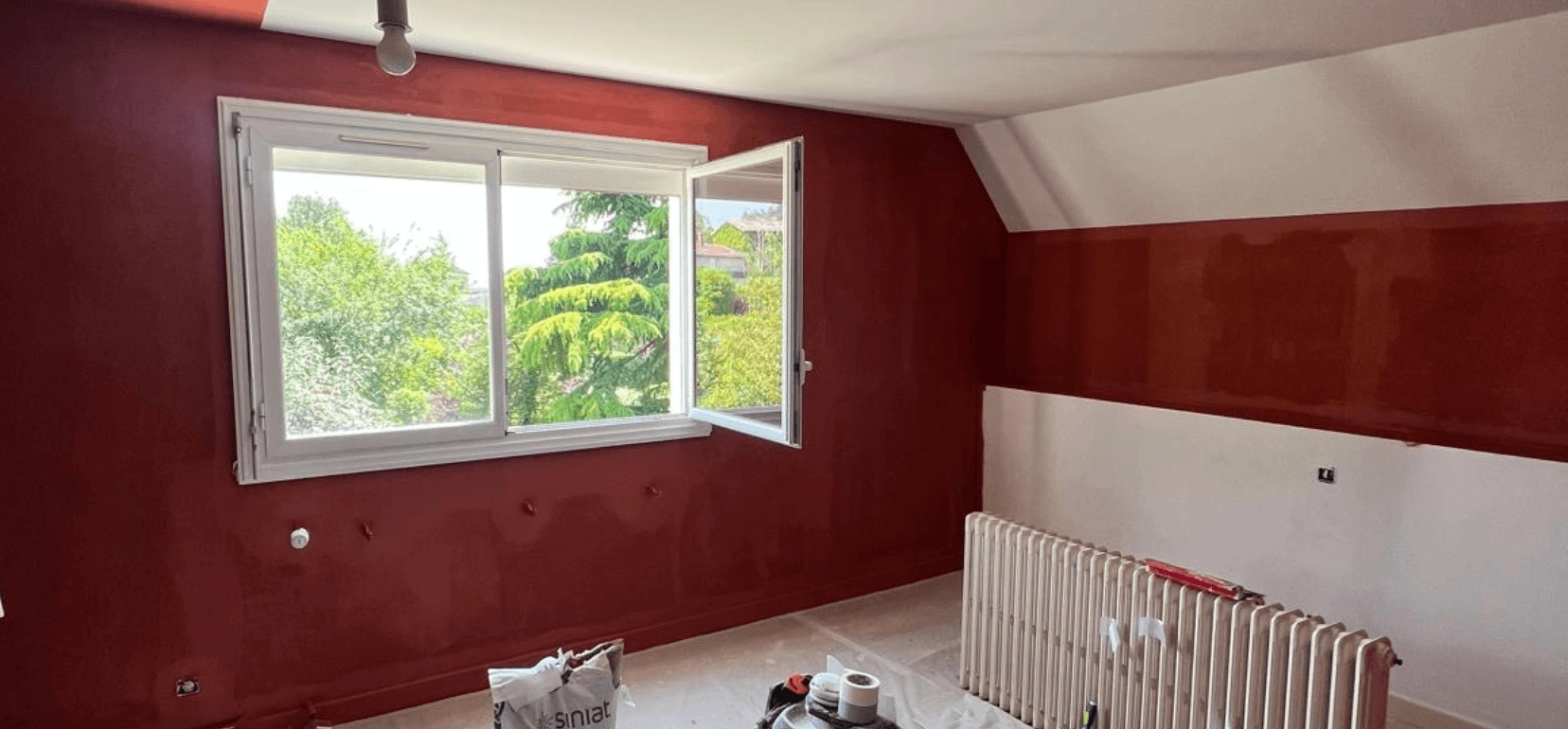 Chambre rénovée par l'entreprise CIM RENOVATION. Chambre peinte avec des murs rouge.