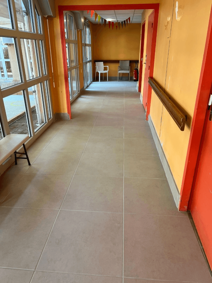 couloir au sols gris et murs jaune rénovée par CIM Rénovation.